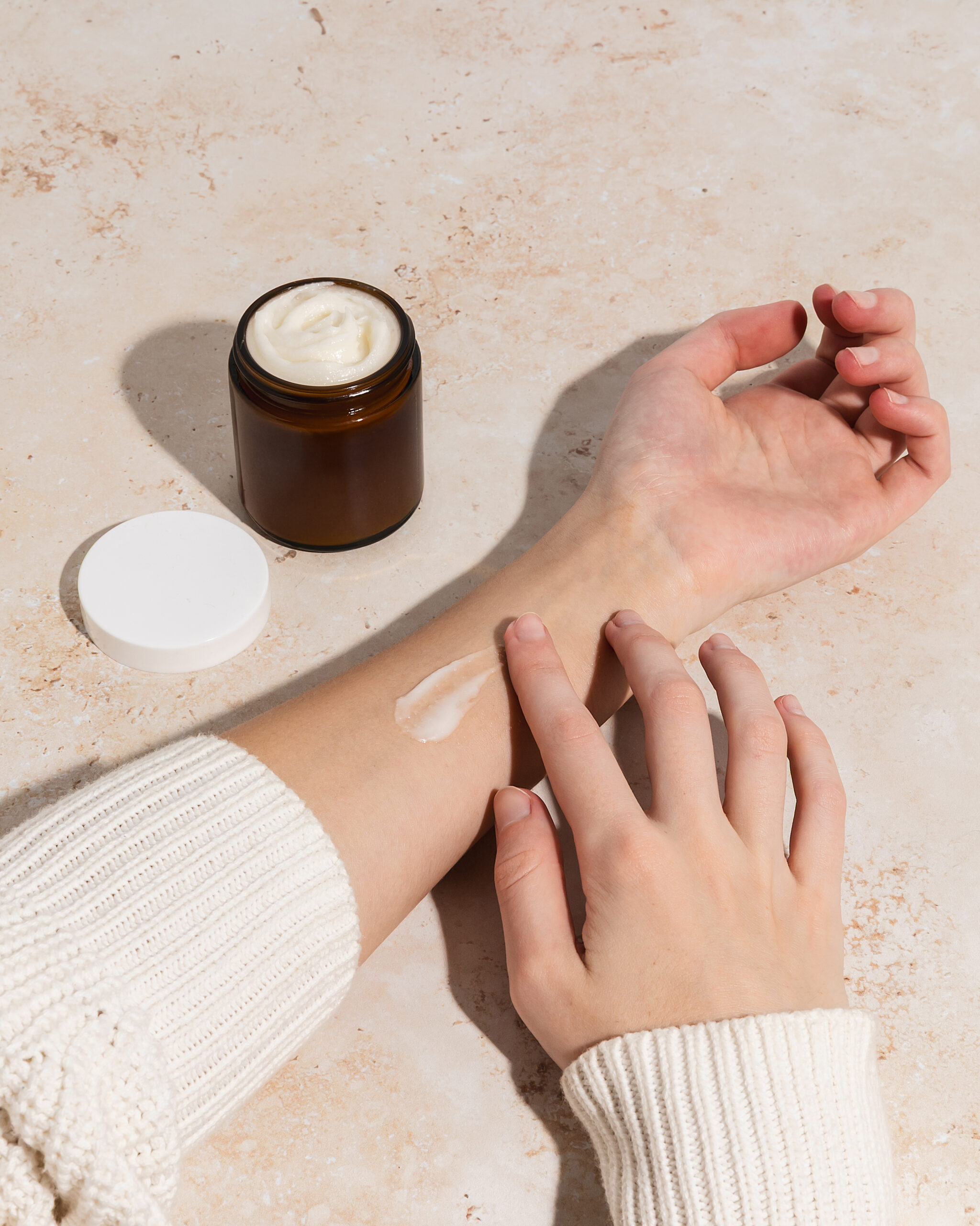 Woman using beef tallow moisturizer with swipe on arm woman using beef tallow on arm